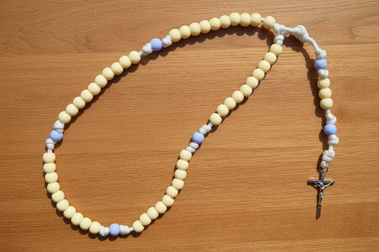 Rosary with yellow and blue beads on a wood background