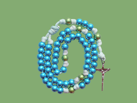 Blue and green beaded paracord rosary with a silver crucifix on a light green background