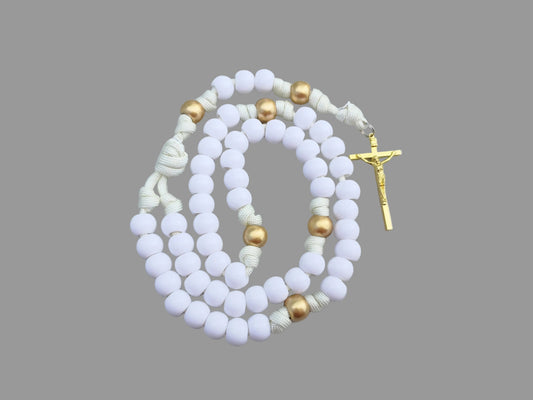 White and gold beaded paracord rosary with a gold colored crucifix on a light gray background